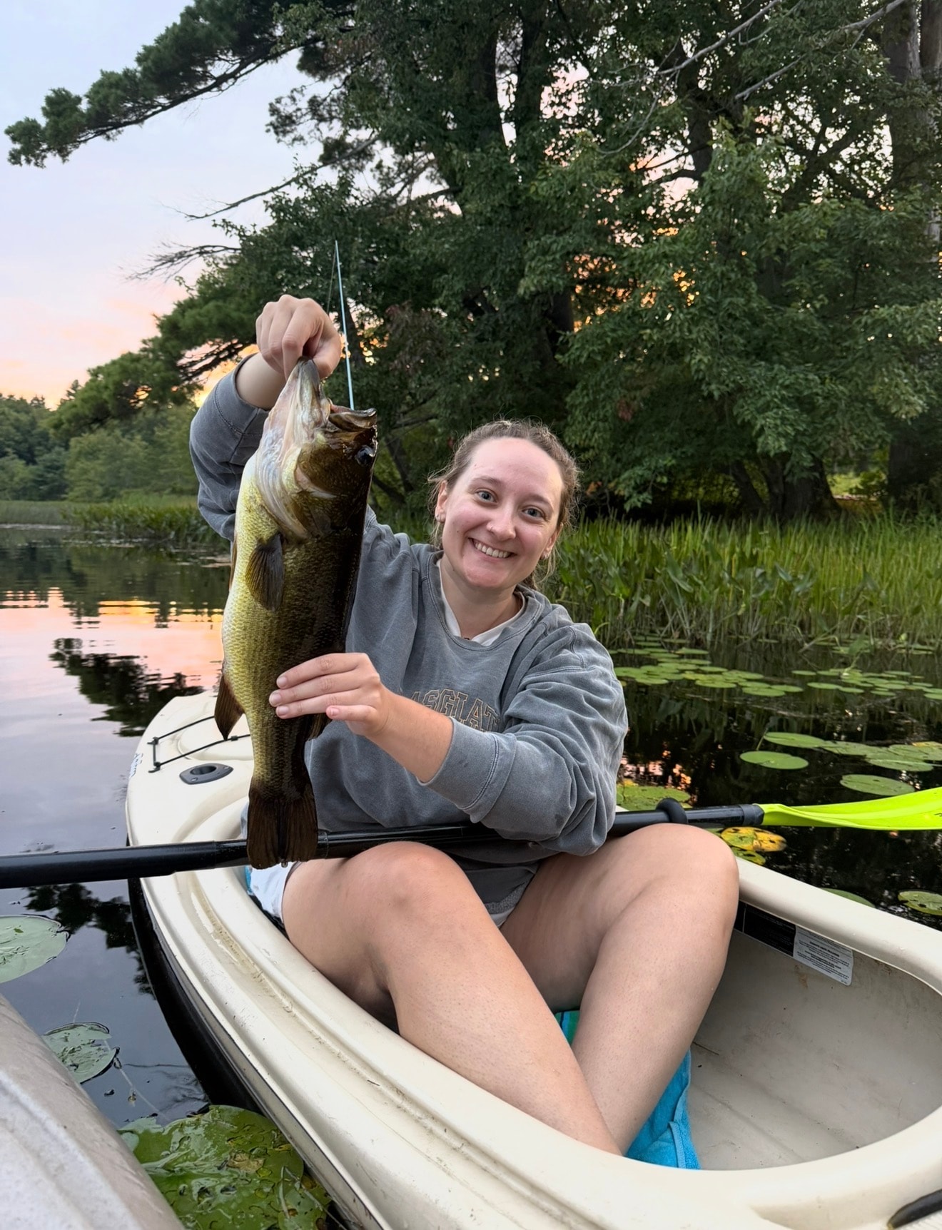 Haley fishing from a kayak at sunset